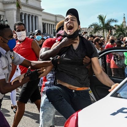 TOPSHOT - A man is arrested during a demonstration against the government of Cuban President Miguel Diaz-Canel in Havana, on July 11, 2021. - Thousands of Cubans took part in rare protests Sunday against the communist government, marching through a town chanting "Down with the dictatorship" and "We want liberty." (Photo by YAMIL LAGE / AFP)