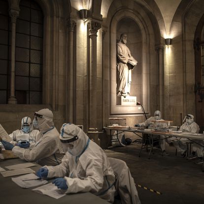 BARCELONA, SPAIN - FEBRUARY 14: Election workers wear protective equipment during the final hour of voting, which was allocated to also allow those who are COVID-positive or who are in quarantine to cast their ballots, at Barcelona University during regional Catalan elections on February 14, 2021 in Barcelona, Spain. In a survey, a third of those chosen by a draw to perform the civic duty of running polling locations on election day said they are worried about the risk of Covid-19 contagion. Spain has been amongst the worst-hit nations by the Coronavirus pandemic, and although the average number of infections has fallen the death rate remains high. (Photo by Finbarr O'Reilly/Getty Images)
