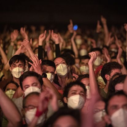 People take part in a music concert in Barcelona, Spain, Saturday, March 27, 2021. Five thousand music lovers are set to attend a rock concert in Barcelona on Saturday after passing a same-day COVID-19 screening to test its effectiveness in preventing outbreaks of the virus at large cultural events. The show by Spanish rock group Love of Lesbian has the special permission of Spanish health authorities. While the rest of the country is limited to gatherings of no more than four people in closed spaces, the concertgoers will be able to mix freely while wearing face masks. (AP Photo/Emilio Morenatti)