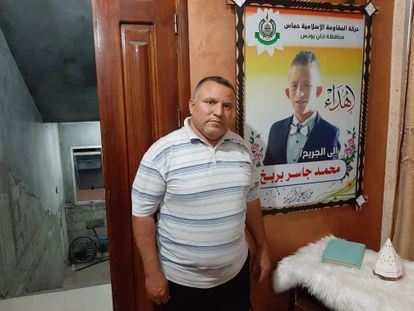 Yasir Barbargh señala un cartel con la foto de su hijo Mohamed, que perdió una pierna en las protestas en la frontera israelí en 2018, en su casa de Jan Yunis (Gaza) el pasado día 13.