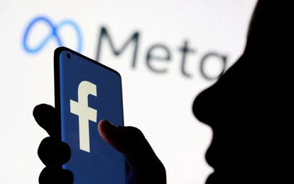 Una mujer sostiene un teléfono inteligente con el logo de Facebook.