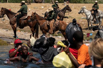 Migrantes cruzan el río Bravo hacia EE UU vigilados por agentes de la Patrulla Fronteriza estadounidense en Texas.
