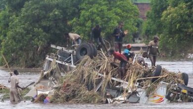 Varias personas, sobre un camión volcado por una riada de agua provocada por la tormenta tropical Ana, el martes en Chikwawa, Malawi.