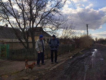 Vasili Grebinik y su vecino Valeri Gobreyev frente a sus casas en Mariinka.