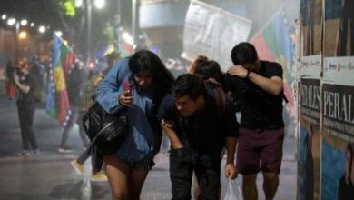 Un grupo de personas huye del cañón de agua utilizado por la policía antidisturbios de Chile, el pasado 17 de diciembre durante una protesta en Santiago.
