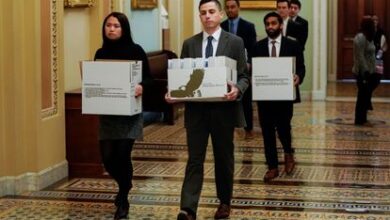 Un grupo de 'staffers' traslada cajas de documentos a la oficina del líder de la minoría del Senado, Chuck Schumer