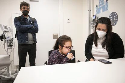 Margarida Fontes realiza una espirometría a la vista de sus padres, Tania e Isaias Fontes, en una consulta de Vall d'Hebron.