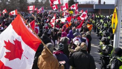 Los agentes forman un cordón policial frente a los manifestantes que apoyan a los camioneros que bloquearon el tráfico del puente Ambassador en Windsor, Ontario.