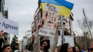 Un grupo de personas sostiene pancartas contra Vladímir Putin en una concentración ante la embajada rusa en Madrid, este jueves.