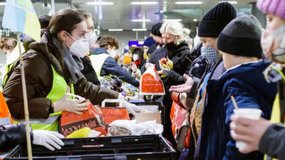 Voluntarios reparten comida y bebidas a refugiados ucranianos llegados a la estación central de Berlín.