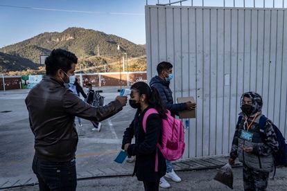 Profesores toman la temperatura a los alumnos antes de ingresar a clases.