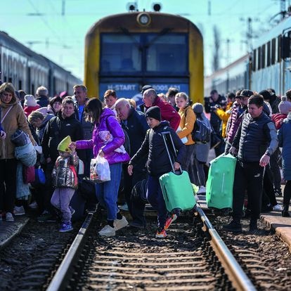 Refugiados ucranios cruzan las vías del tren en Zahony, Hungría.