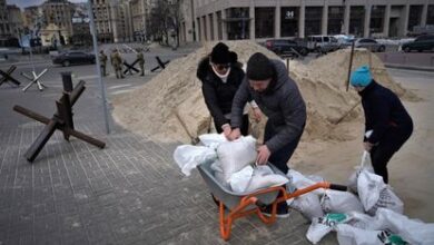 Un grupo de civiles prepara sacos terreros para construir barricadas en Kiev.