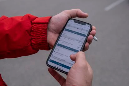Las manos de Florin Bosnea mostrando en su móvil la aplicación Amazon Relay.