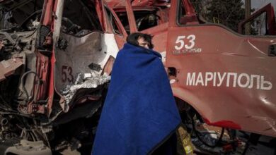 Una mujer se cubre con una manta cerca de un camión de bomberos tras un bombardeo en Mariupol, este jueves.