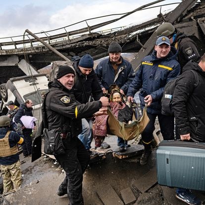 Una anciana cruza el río con ayuda, mientras los civiles huyen de Irpin, el 8 de marzo.
