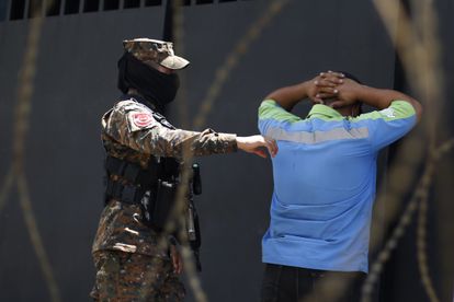 Un soldado detiene este lunes a un hombre en un punto de control en Santa Tecla (El Salvador).