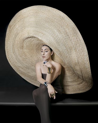 Pulseras Bone Cuff en oro y plata, creación que en 2019 cumplió 50 años y probablemente sea el diseño más icónico de Elsa Peretti para Tiffany & Co. Sombrero de paja natural de Eliurpi y vestido tubo de Wolford.