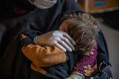 Una madre acuna a su hijo dentro de uno de los espacios seguros para mujeres y niñas de un campo de refugiados.