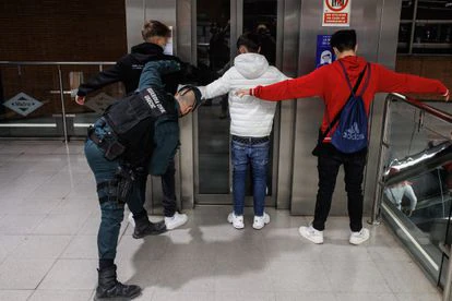 Dos agentes de la Guardia Civil cachean a dos jóvenes en un control para prevenir la violencia entre bandas juveniles, en la estación de metro de Arganda del Rey, el pasado 11 de febrero.