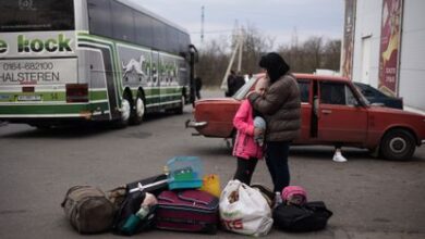 Natasha Sarkisiyan y su hija lloran mientras esperan con sus maletas y la jaula de sus pájaros un autobús para ser evacuadas de Kramatorsk.