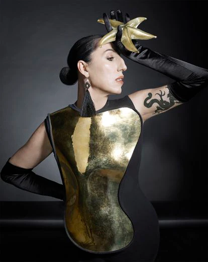 Pendientes Tase de oro, perlas y seda negra. A su llegada a Tiffany en 1974, Peretti quiso llevar esa emoción que sintió en Japón a la realidad y junto a artesanos nipones diseñó varias joyas tejidas en seda negra como estas borlas que cuelgan de una perla. Estrella de mar en cristal veneciano soplado a mano, todo de Elsa Peretti para Tiffany & Co. Vestido joya de Loewe y guantes negros de Guante Varadé.