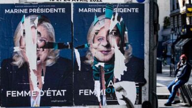 Carteles electorales de Marine Le Pen que han sido rasgados, este sábado en París.