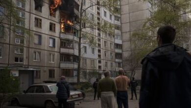 Unos vecinos observaban los daños en un edificio tras un ataque ruso, este lunes en Járkov.