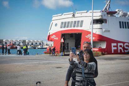Dos pasajeros se hacen un selfi delante del barco que les llevará hasta Tánger, este jueves.