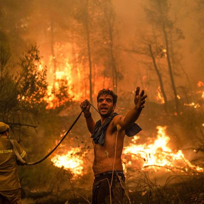 -- AFP PICTURES OF THE YEAR 2021 --

A local resident gestures as he holds n empty water hose during an attempt to extinguish forest fires approaching the village of Pefki on Evia (Euboea) island, Greece's second largest island, on August 8, 2021. - Hundreds of Greek firefighters fought desperately on August 8 to control wildfires on the island of Evia that have charred vast areas of pine forest, destroyed homes and forced tourists and locals to flee. Greece and Turkey have been battling devastating fires for nearly two weeks as the region suffered its worst heatwave in decades, which experts have linked to climate change. (Photo by ANGELOS TZORTZINIS / AFP) / AFP PICTURES OF THE YEAR 2021
