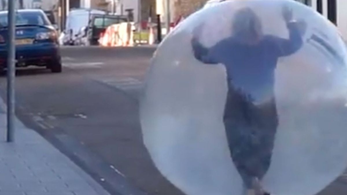 Una mujer va al supermercado dentro de una burbuja de plástico