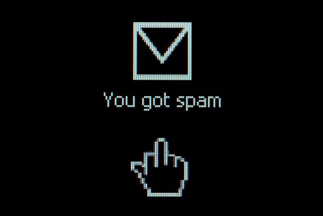 Cómo bloquear textos de spam | ¿Por qué recibo mensajes de texto no deseados? ícono de mensaje en un fondo negro que dice que recibió spam con un ícono de mano que muestra el dedo medio