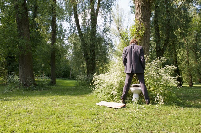 empresario de reciclaje de orina usando el baño en el parque