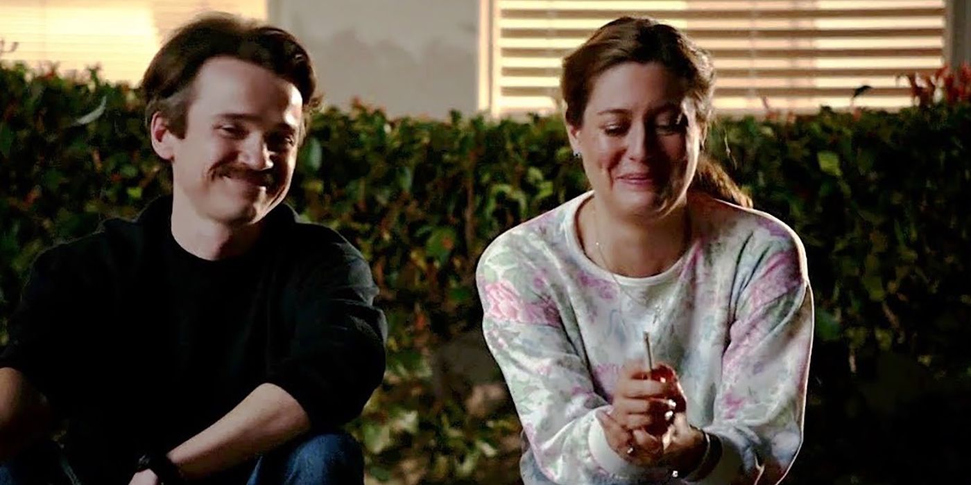 El pastor Rob y Mary comparten un cigarrillo afuera, riéndose juntos de Young Sheldon.