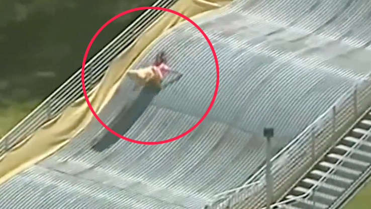 niños y adultos vuelan en el aire al deslizarse por enorme tobogán en Detroit