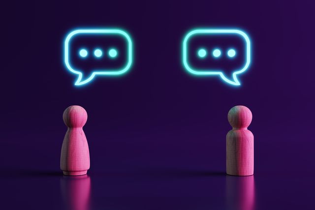 dos figuras de personas de madera comunicándose