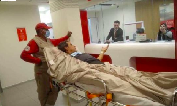Hombre llega en camilla a un banco, fue requerido de manera presencial para un trámite