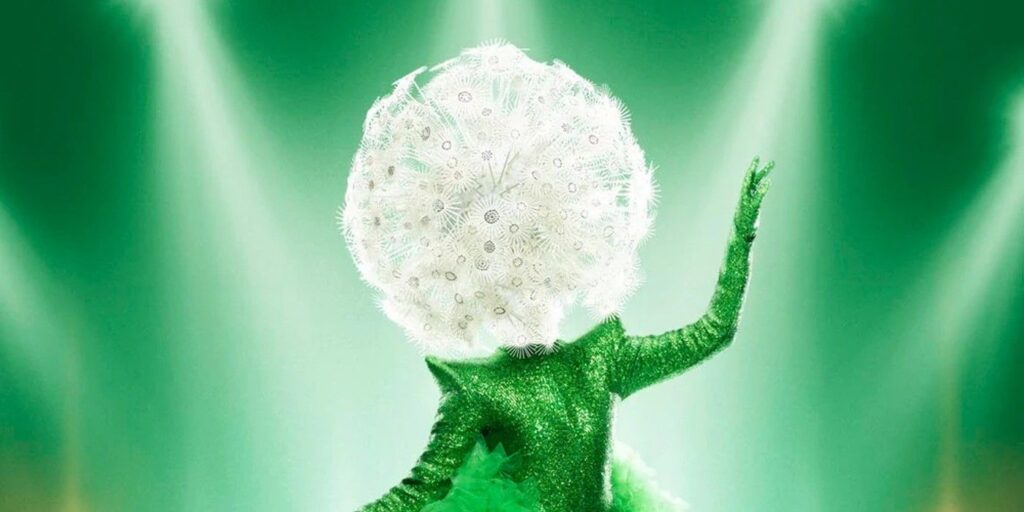 The Masked Singer Season 9 Dandelion posing in front of green background