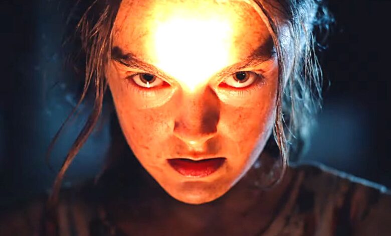 A creepy kid shining a light on their face in the dark in the new Children of the Corn remake