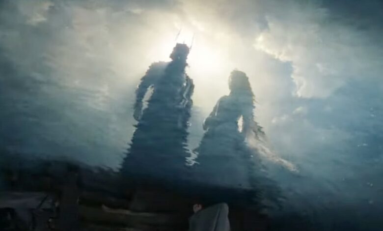 Sauron and Galadriel looking at reflections in the water
