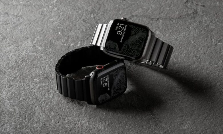 Nomad's black and silver titanium Apple Watch bands on two Apple Watch units.