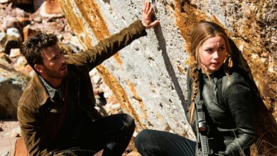 Chris Evans as Cole Turner and Ana de Armas as Sadie Rhodes hiding against rock in Ghosted
