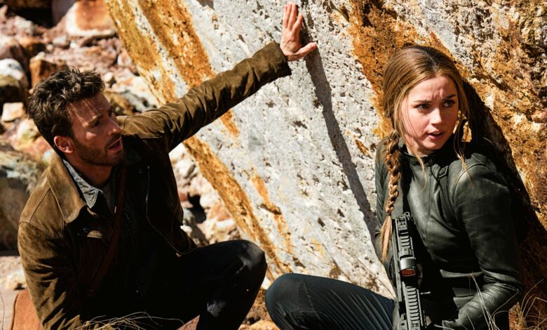 Chris Evans as Cole Turner and Ana de Armas as Sadie Rhodes hiding against rock in Ghosted
