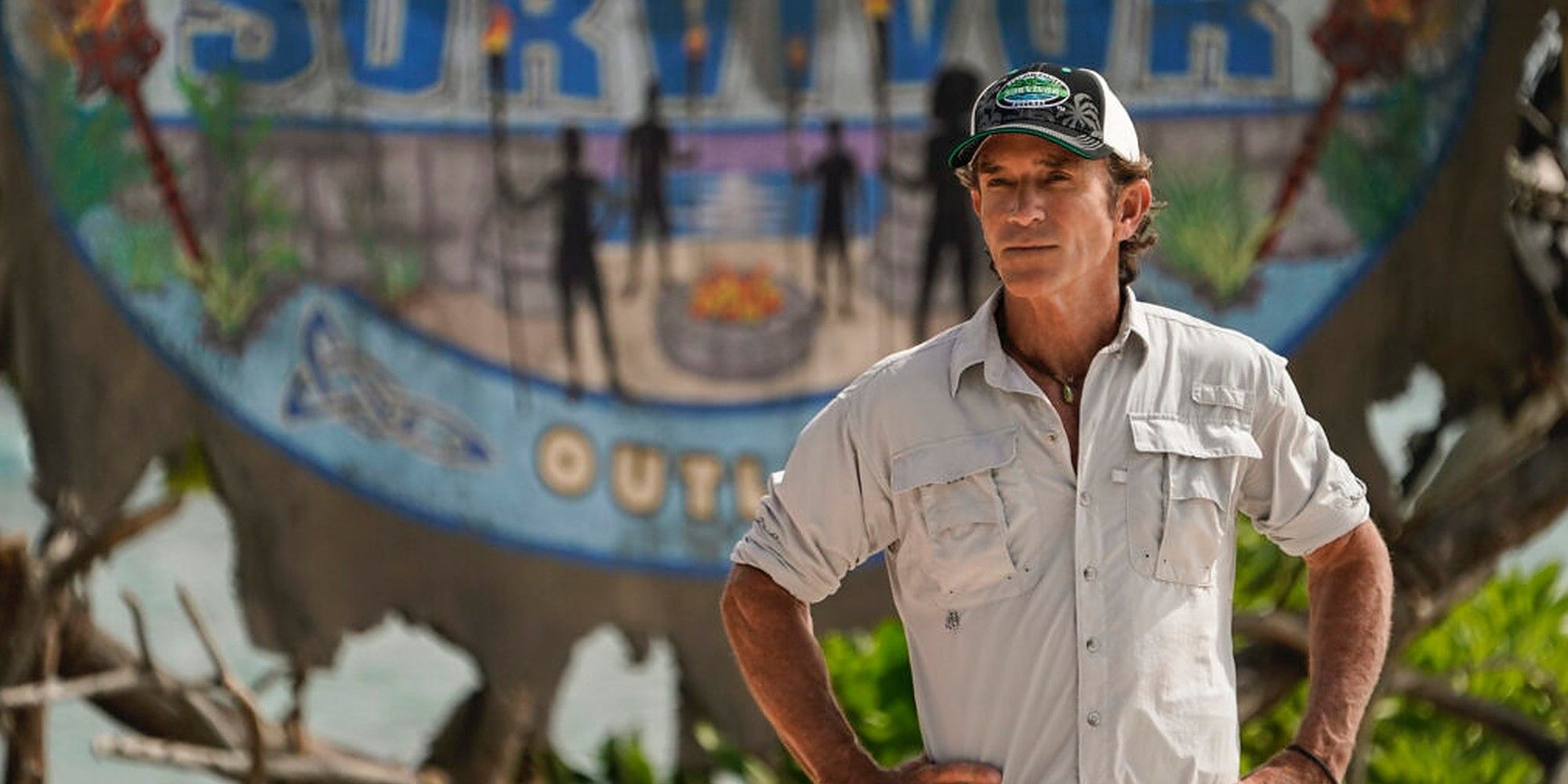Jeff Probst - Survivor 44 wearing baseball cap in front of outlast logo