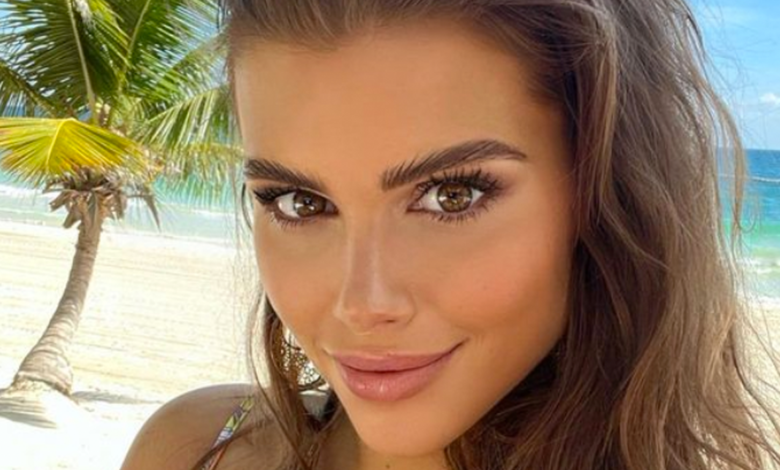 Katharina RHOM Lenny's Mistress in front of a beach smirking
