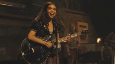 Rachel Zegler playing guitar and singing