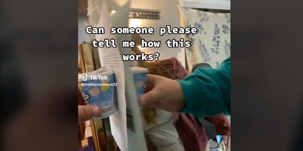 A screenshot showing showing a container of gum and piece of paper held against a mirror