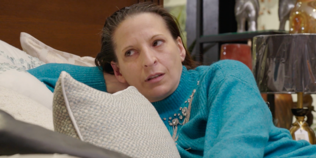 Kris Foster from 90 Day Fiance: The Other Way leaning on pillow serious expression