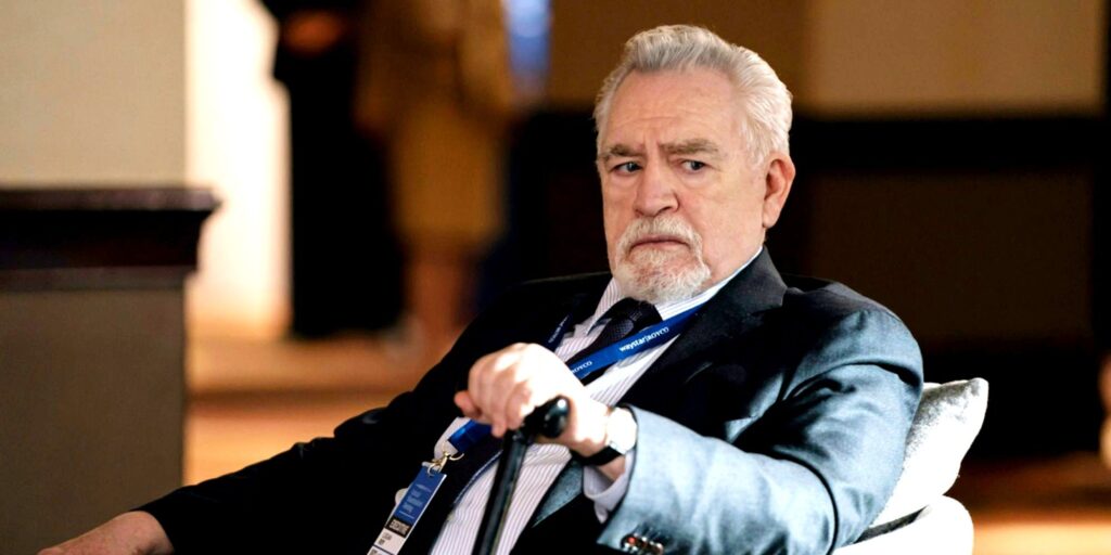 Logan looking annoyed while holding his cane sitting in Succession