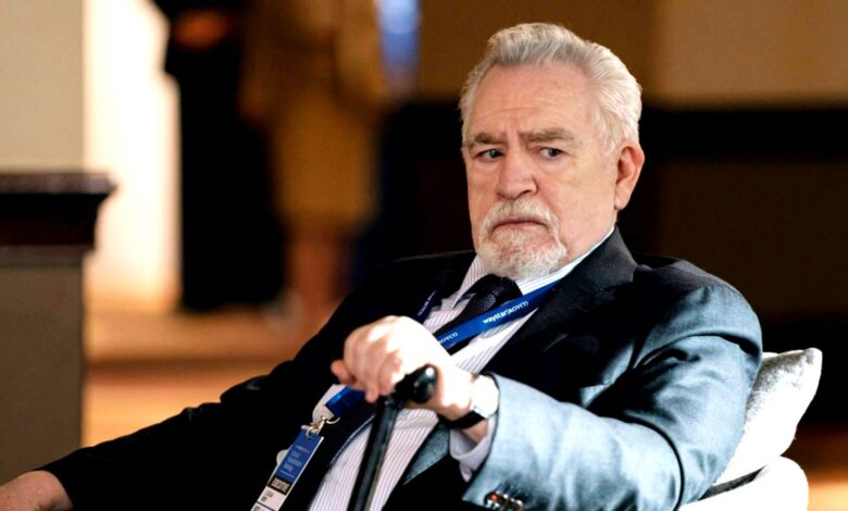 Logan looking annoyed while holding his cane sitting in Succession